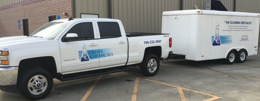 A white truck parked in the parking lot next to another truck.